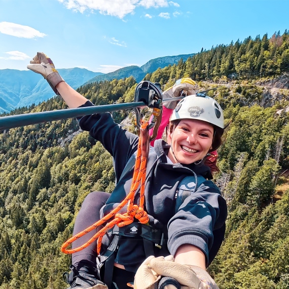 Person using a zipline above a forest.