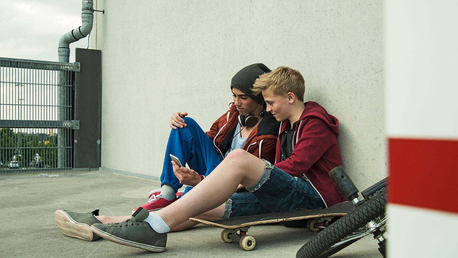 Boys sat on floor at skate park